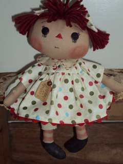   her dress is made from a tan cotton fabric with red green and blue