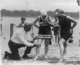 1922 policeman measuring bathing suit on woman  